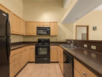 a kitchen with wooden cabinets and black appliances