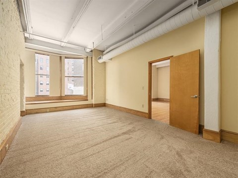 an empty room with two windows and a door