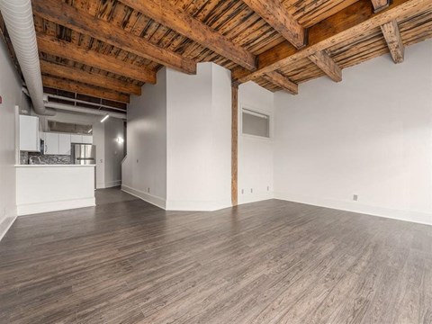 an empty living room with wood floors and white walls