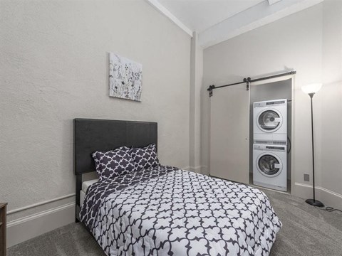 a bedroom with a bed and a washer and dryer at East 4th Street, Cleveland, OH