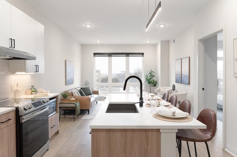 an open kitchen and living room with a large counter top