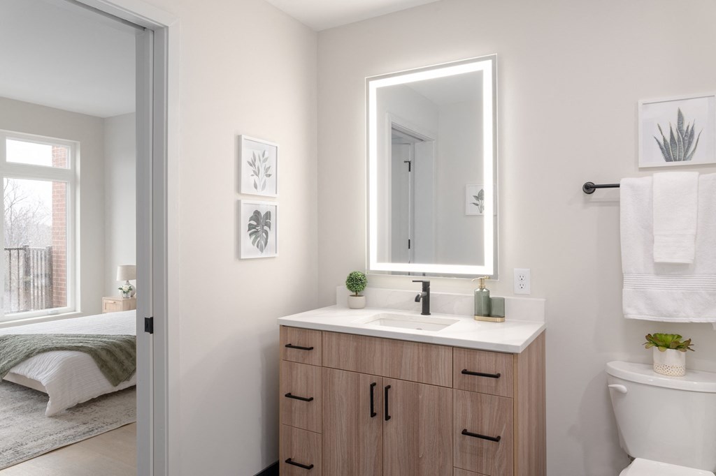 a bathroom with a sink and a mirror and a door to a bedroom in Rocky River, OH 44116