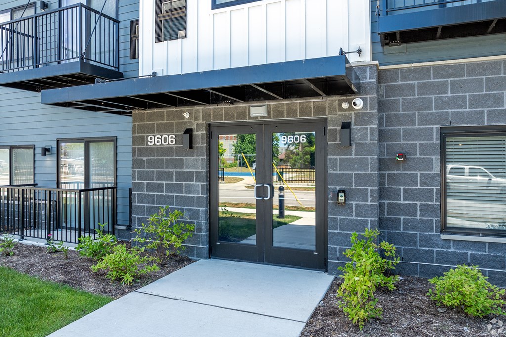 The image shows a modern building entrance with a glass door and a number plate above it. at Park Lamont Townhomes Apartments, Cleveland, OH, 44106