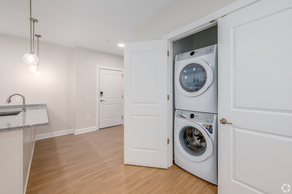 A white washer and dryer are tucked into a small space in a home. at Park Lamont Townhomes Apartments, Cleveland, Ohio