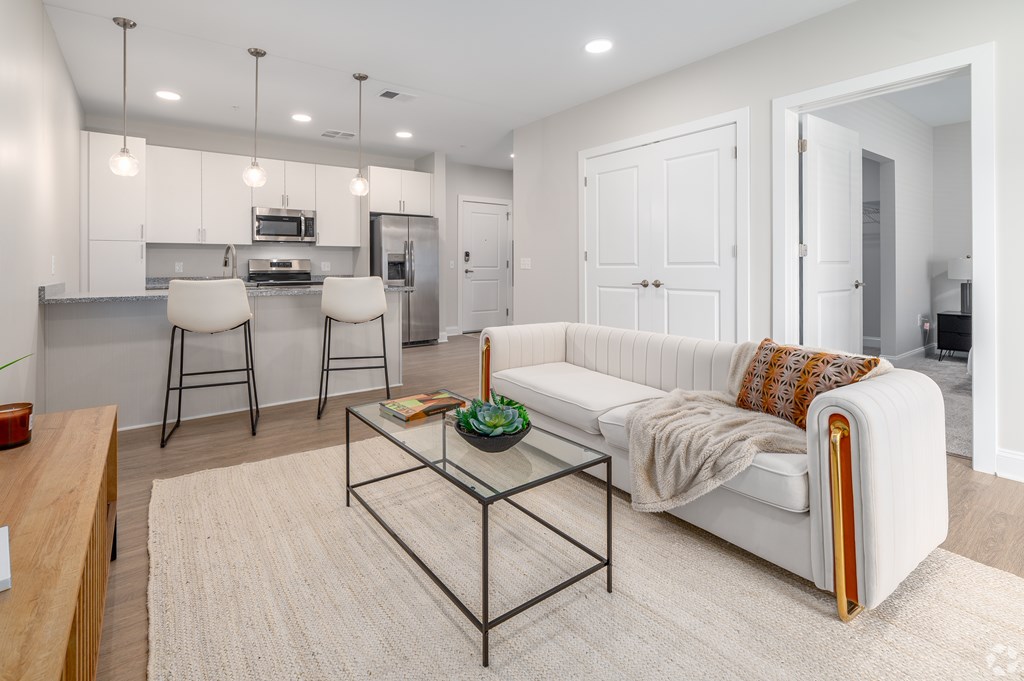 A modern living room with a white sofa and a glass coffee table. at Park Lamont Townhomes Apartments, Cleveland 44106