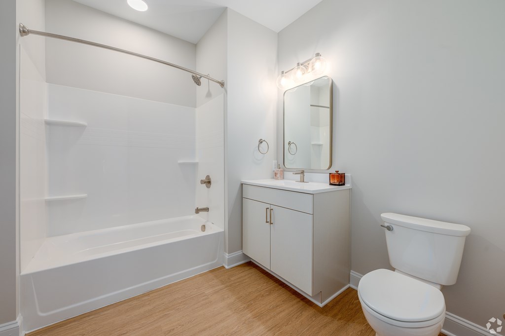 A white bathroom with a toilet, sink, and bathtub at Park Lamont Townhomes Apartments, Cleveland, Ohio