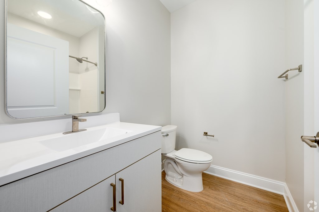 A white bathroom with a toilet and sink. at Park Lamont Townhomes Apartments, Cleveland, Ohio