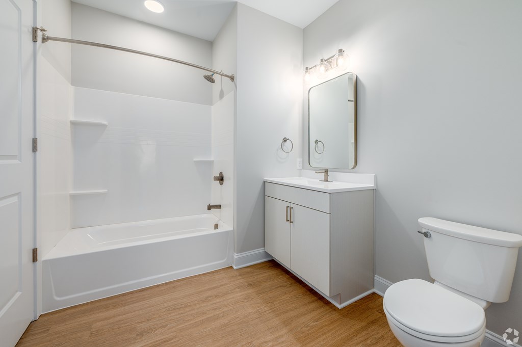 A white bathroom with a toilet, sink, and bathtub. at Park Lamont Townhomes Apartments, Cleveland, OH