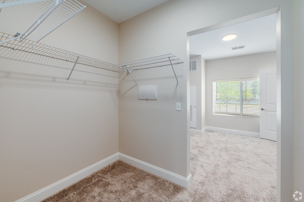 A room with a carpeted floor and a door leading to another room. at Park Lamont Townhomes Apartments, Cleveland, OH