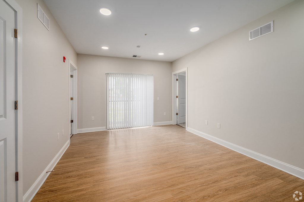 A large empty room with wooden floors and white walls. at Park Lamont Townhomes Apartments, Ohio