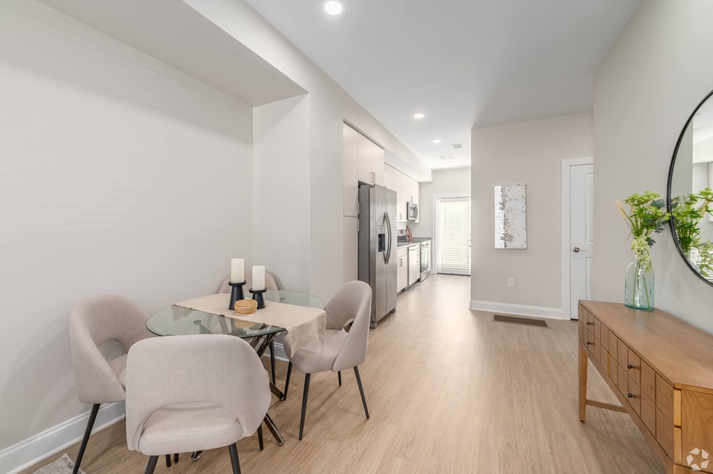A modern dining room with a glass table and chairs. at Park Lamont Townhomes Apartments, Ohio