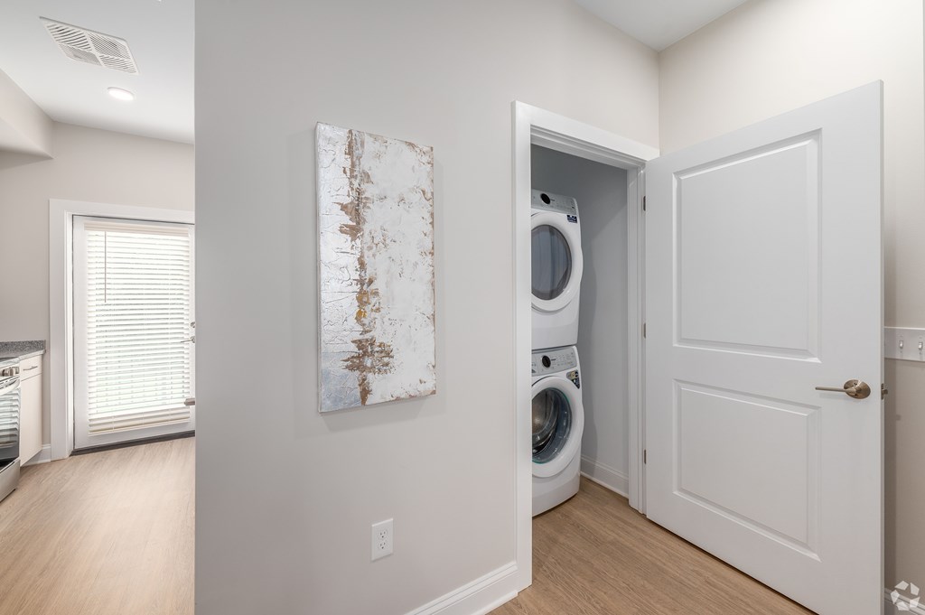A white door is open to a laundry room with a washer and dryer. at Park Lamont Townhomes Apartments, Cleveland, OH
