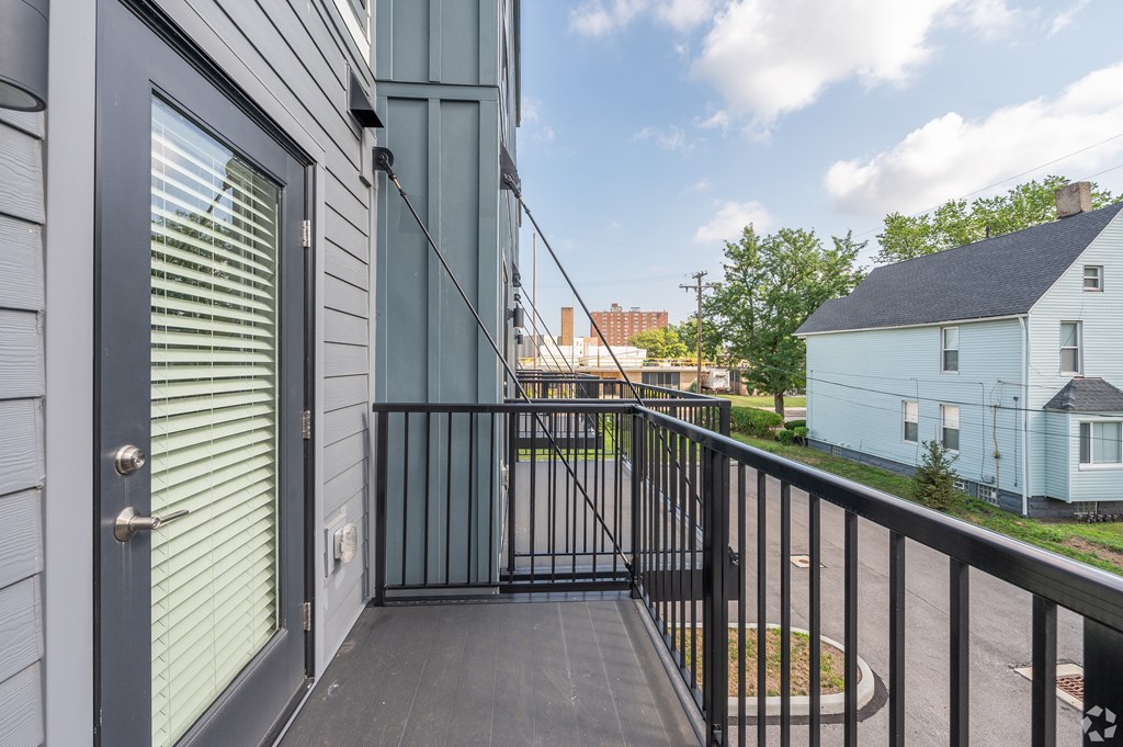 A balcony with a black railing and a door with a window. at Park Lamont Townhomes Apartments, Ohio, 44106