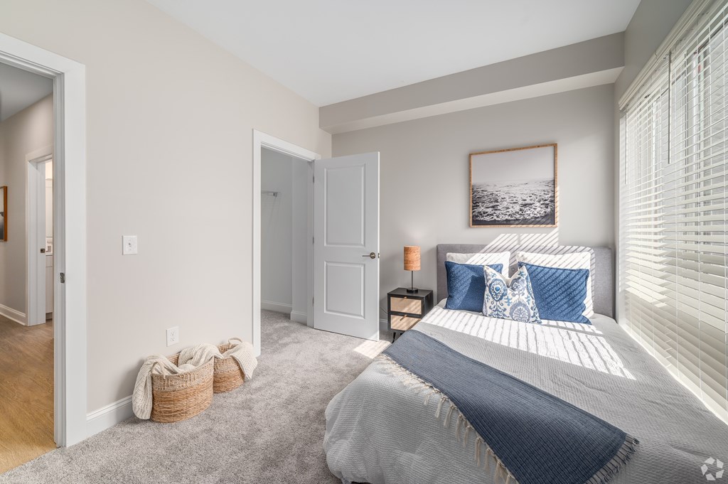 A bedroom with a large bed and a picture on the wall. at Park Lamont Townhomes Apartments, Cleveland, OH, 44106