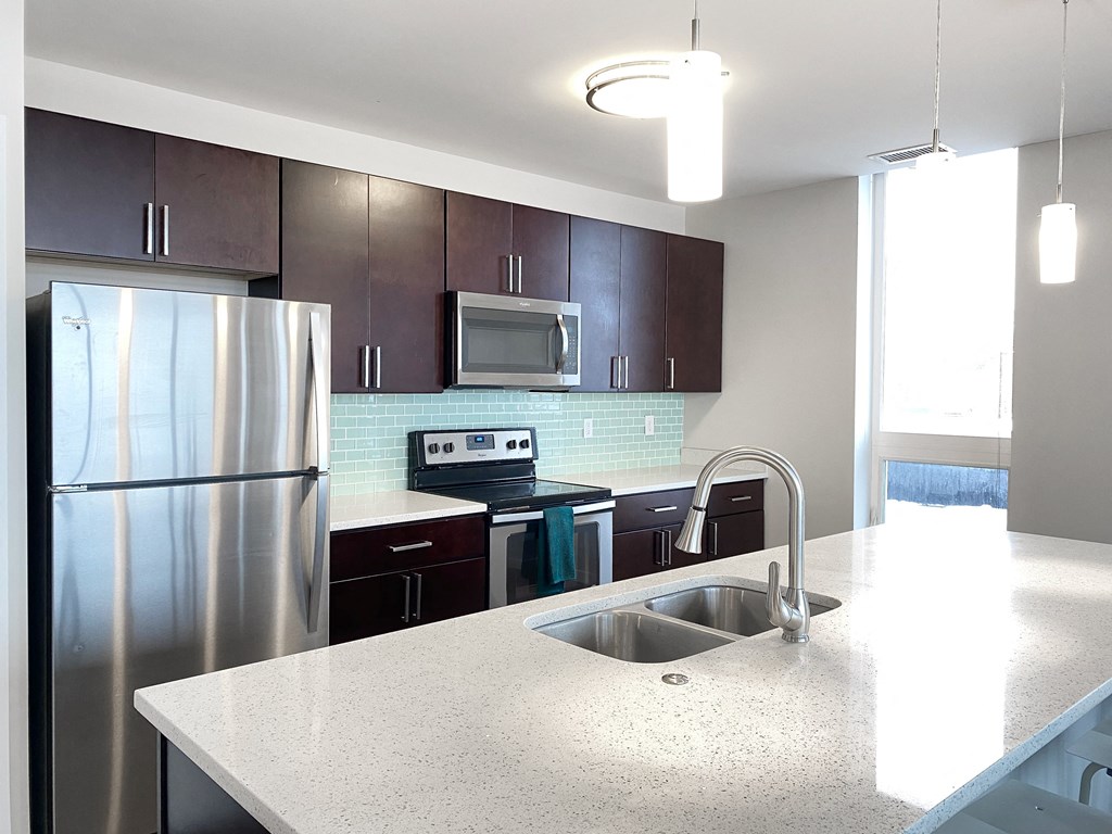 a kitchen with stainless steel appliances and a white counter top