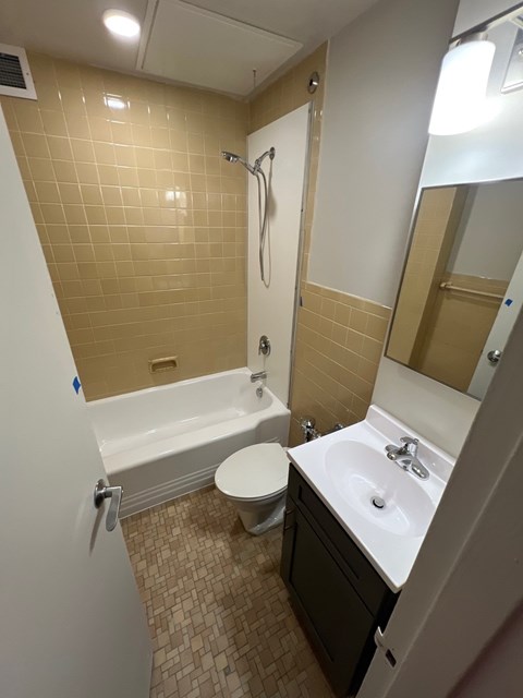 A bathroom with a toilet, sink, and bathtub.
