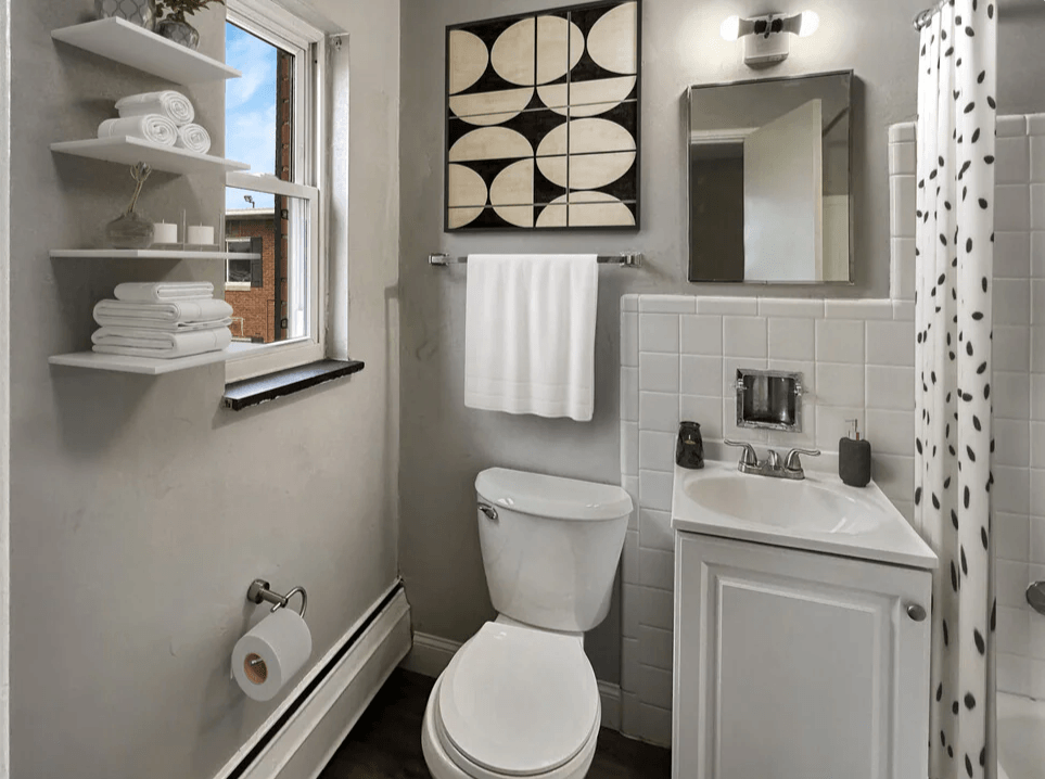 a bathroom with a toilet and a sink and a window