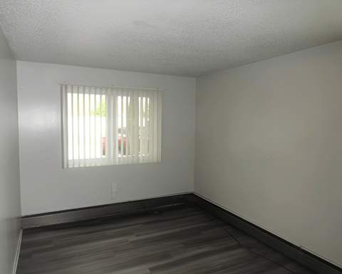 A room with a window and wooden floors.
