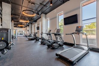 a room filled with cardio equipment and a flat screen tv at TREO Apartments, Cleveland, 44116
