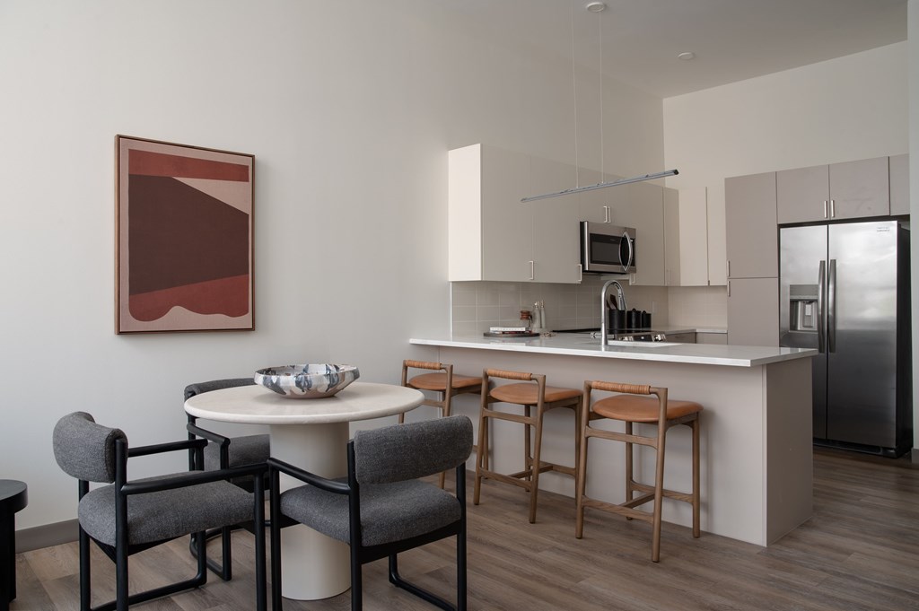 A modern kitchen with a dining table and chairs.