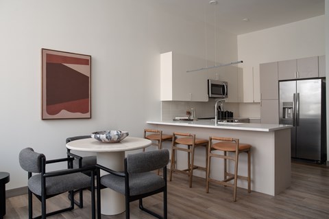A modern kitchen with a dining table and chairs.