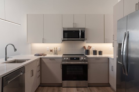 A modern kitchen with stainless steel appliances and white cabinets.