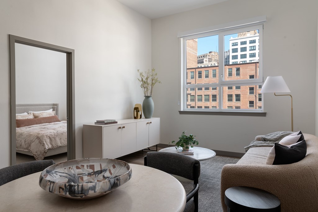 A modern bedroom with a large window overlooking a cityscape.