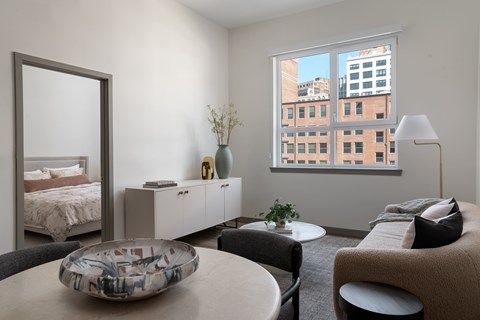A modern bedroom with a large window overlooking a cityscape.