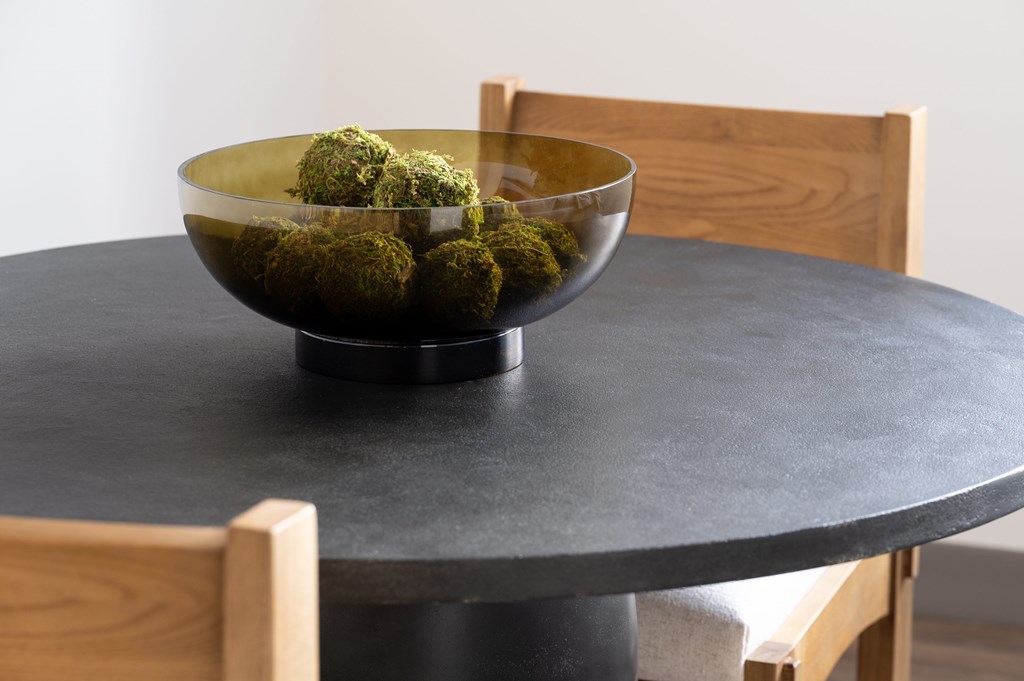 A bowl of green balls sits on a table.