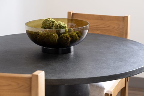 A bowl of green balls sits on a table.