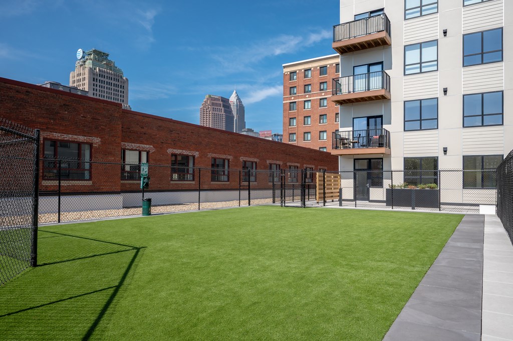 A large grassy area in front of a building with a fence.