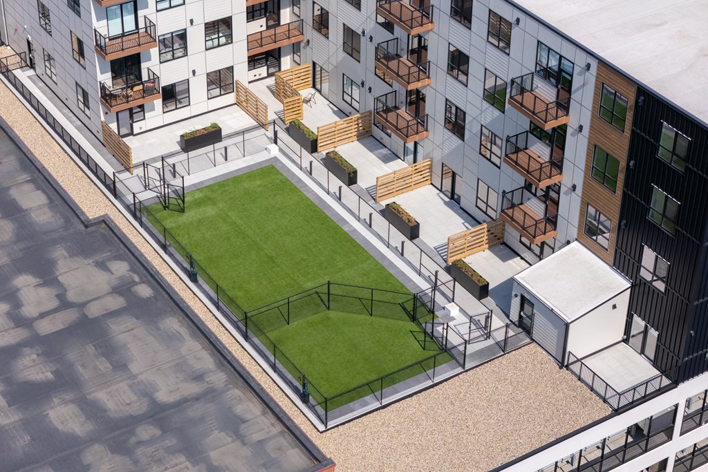 A modern apartment complex with a green space in the courtyard.