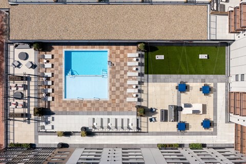 A modern building with a pool and a green area.