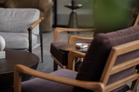 A brown chair with a wooden frame and a brown cushion is in the foreground.