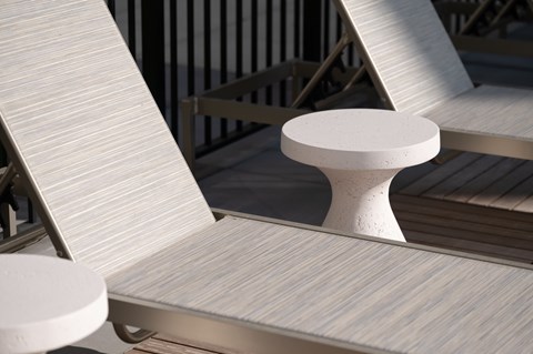 A white chair with a round back is placed on a wooden deck.