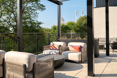 A patio with white cushions and black metal railings.