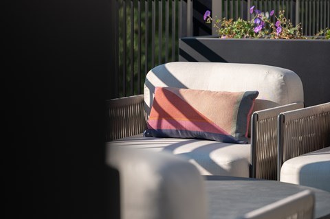 A white chair with a striped pillow is in the foreground.