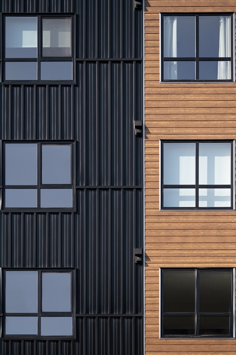 A tall building with a black and brown facade.
