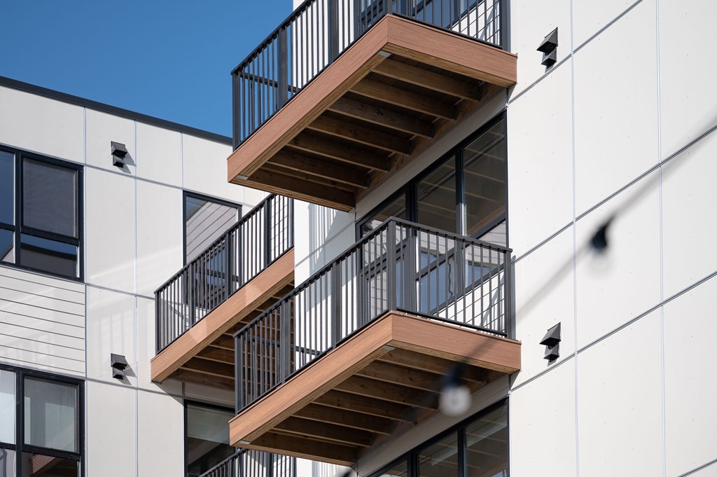 A modern building with a balcony and a metal railing.
