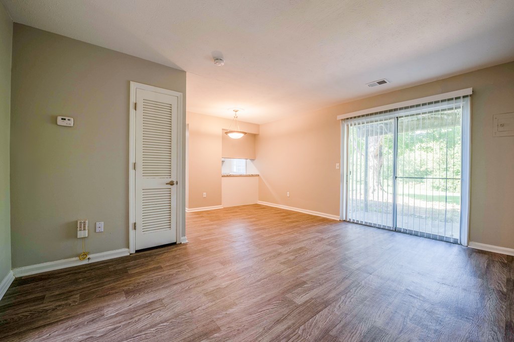 A room with wooden flooring and a sliding glass door.