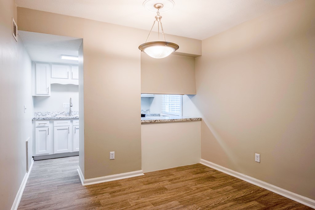 A room with a window and a wooden floor.