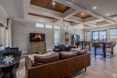 A living room with a brown couch and a fireplace.