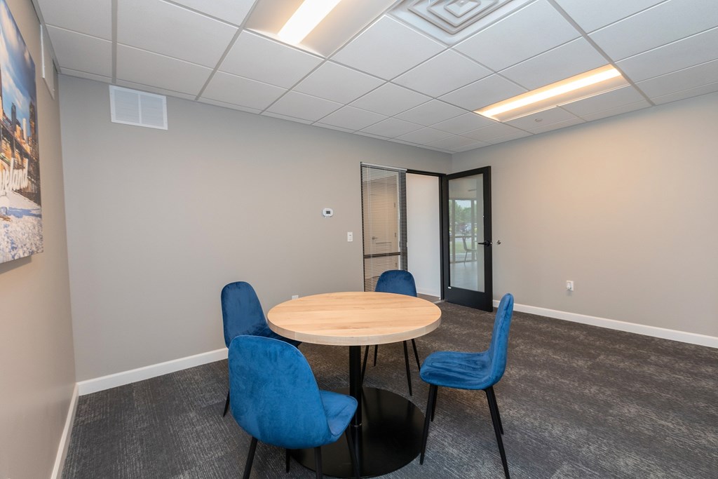 A conference room with a round table and four chairs. at The Lumos Apartments, Cleveland, OH