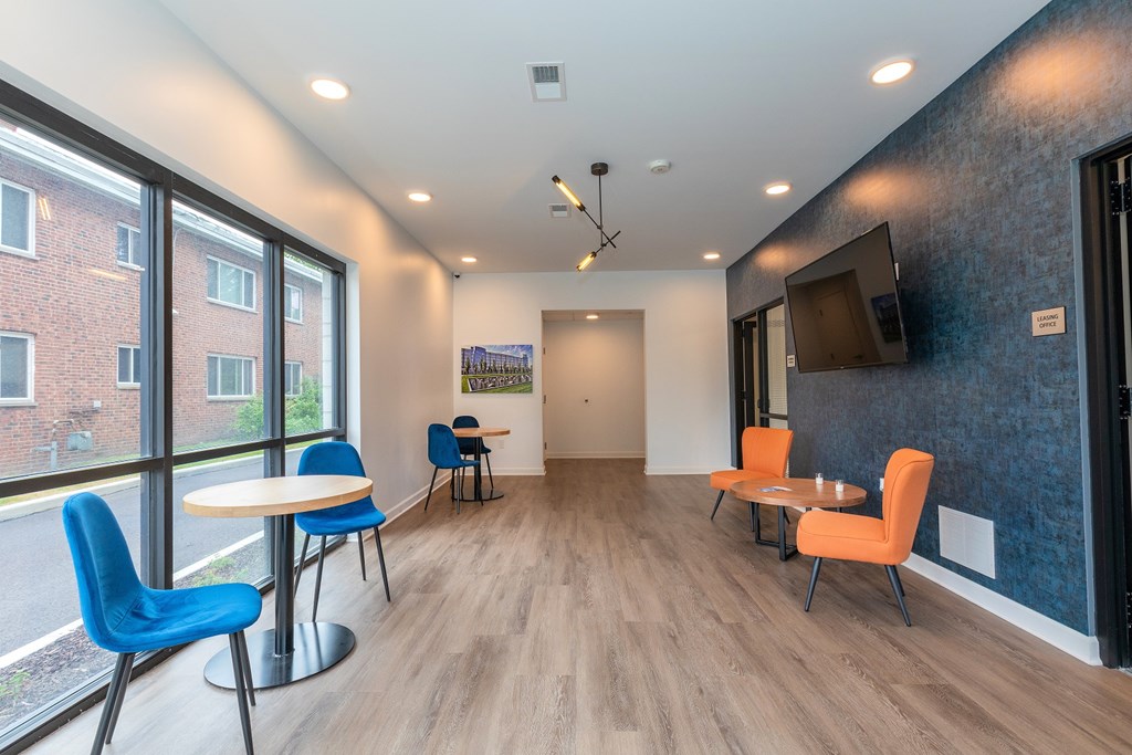A room with a white table and blue chairs. at The Lumos Apartments, Ohio, 44106