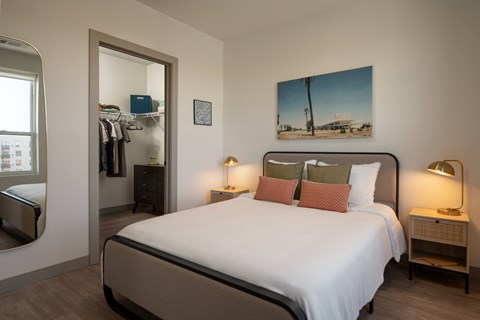 A bedroom with a large bed and a painting on the wall.
