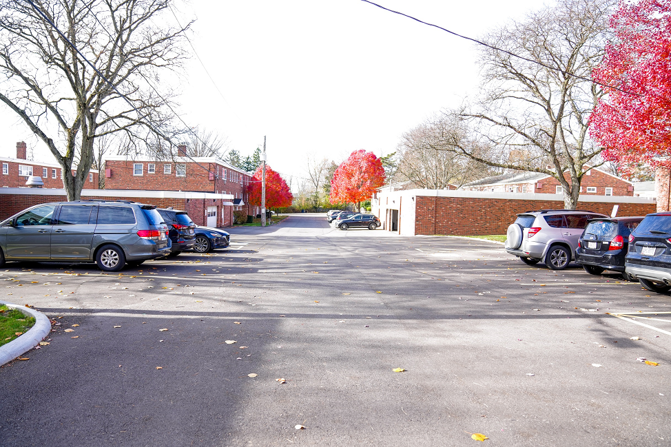 a parking lot filled with cars in front of a brick building