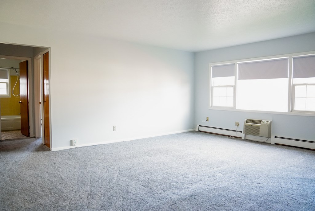 an empty room with a white wall and a window