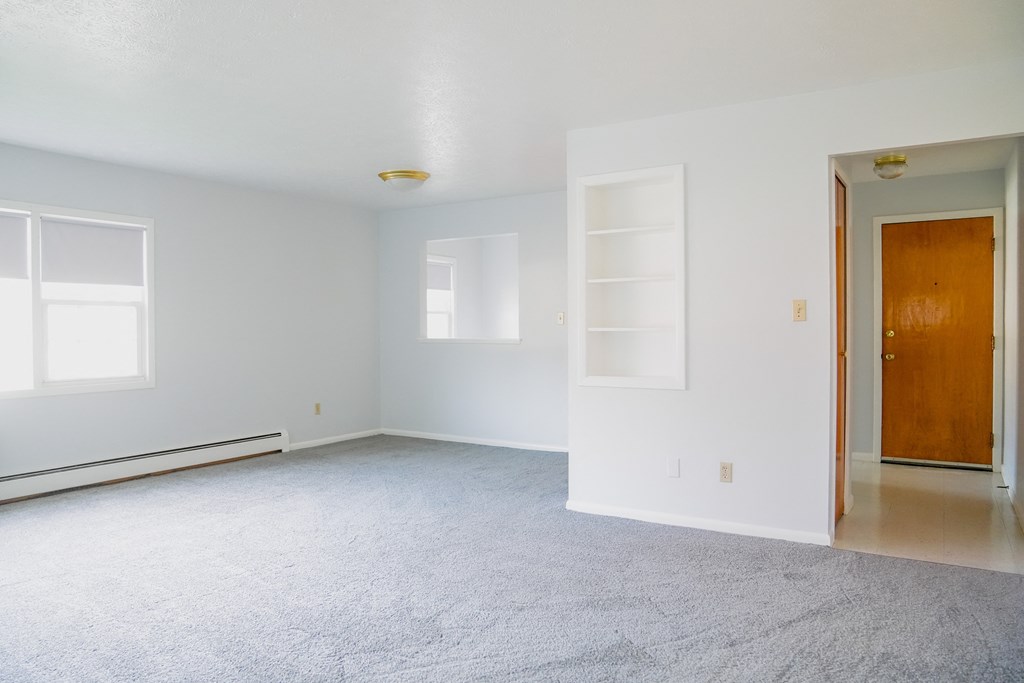 an empty living room with white walls and white carpet