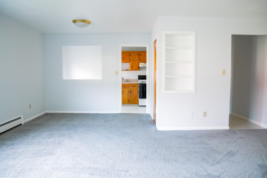 an empty living room with white walls and a white carpet