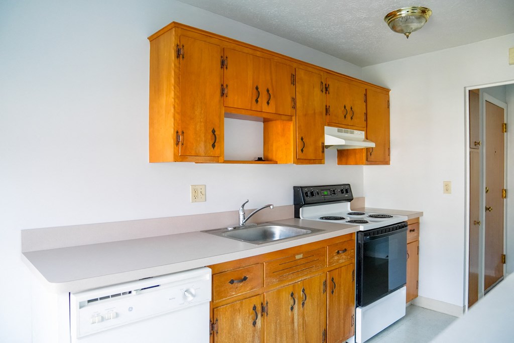 a kitchen with white appliances and wooden cabinets